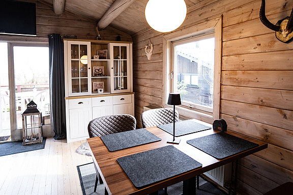 Esszimmertisch mit eleganter Vitrine im Ferienhaus 'Zweite Heimat', stilvoll und modern eingerichtet. Esszimmertisch mit eleganter Vitrine im Ferienhaus 'Zweite Heimat', stilvoll und modern eingerichtet.