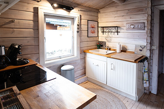 Gesamtansicht der modernen Küche im Ferienhaus 'Zweite Heimat', mit eleganter Ausstattung und offenen Regalen. Gesamtansicht der modernen Küche im Ferienhaus 'Zweite Heimat', mit eleganter Ausstattung und offenen Regalen.